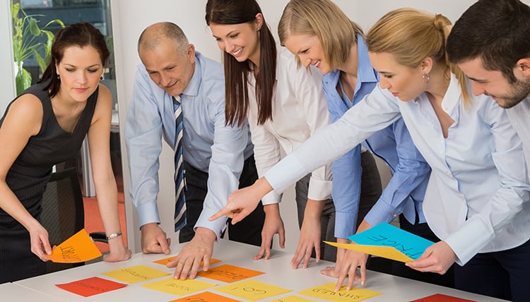 Business team brainstorming using color labels on table in office